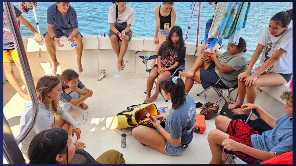 Anticipating the wave's arrival, on July 29, 2025, the Sea Scouts conduct a safety training with the boat's emergency bag. Ensure it contains flares, an emergency beacon, and other essential items needed in case of an emergency. (Picture Courtesy: Larry Richardson/ Kaua’i Sea Scouts)