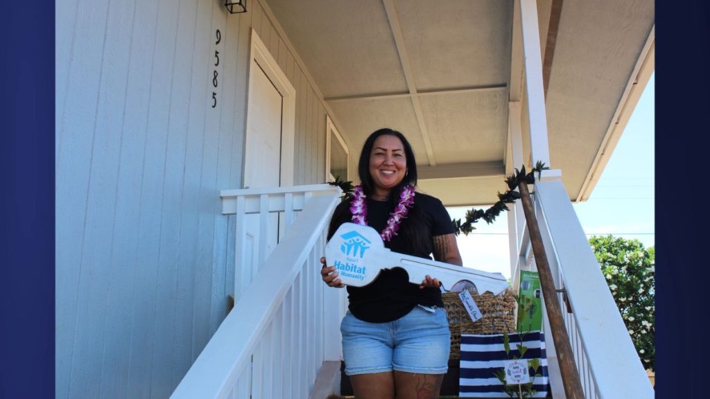 Janelle B. poses with the Kauaʻi Habitat ceremonial key after receiving the official keys to her new home in Waimea. (Photo credit: Kauaʻi Habitat for Humanity)