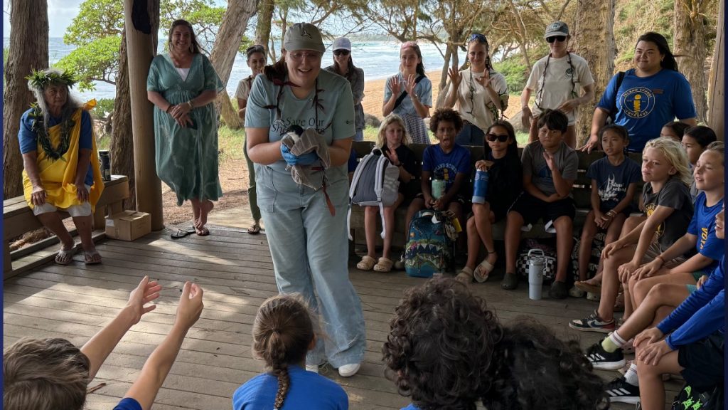 Jacqueline Nelson, senior program manager at Save Our Shearwater, introduces the children to an endangered 'A'o bird before it is released. (Photo Credit: Xiomara Yamileth/ Kaua'i Now)