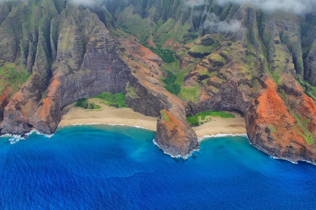 According to Hawaiian legend, the goddess Pele once journeyed along the Nāpali Coast, shaping its cliffs and valleys through her fiery battles with her sister Namakaokaha‘i, goddess of the sea. Their elemental struggle—fire against water—helped form the dramatic landscapes that define Kaua‘i’s rugged beauty today.