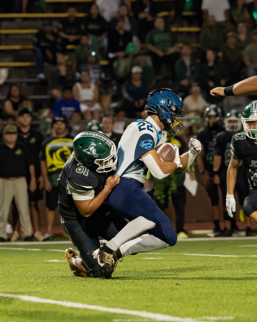 Kapaʻa High School's Zamana Labanon (51) tackles Kailua's Marquez Mellor (22). (Kinue Miller/ScoringLive)