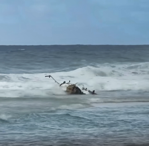 A tour helicopter operated by Airborne Aviation crashed just offshore of Kauaʻi's remote Kalalua Beach on March 26, 2026. Screenshot of Ryan Heringer video