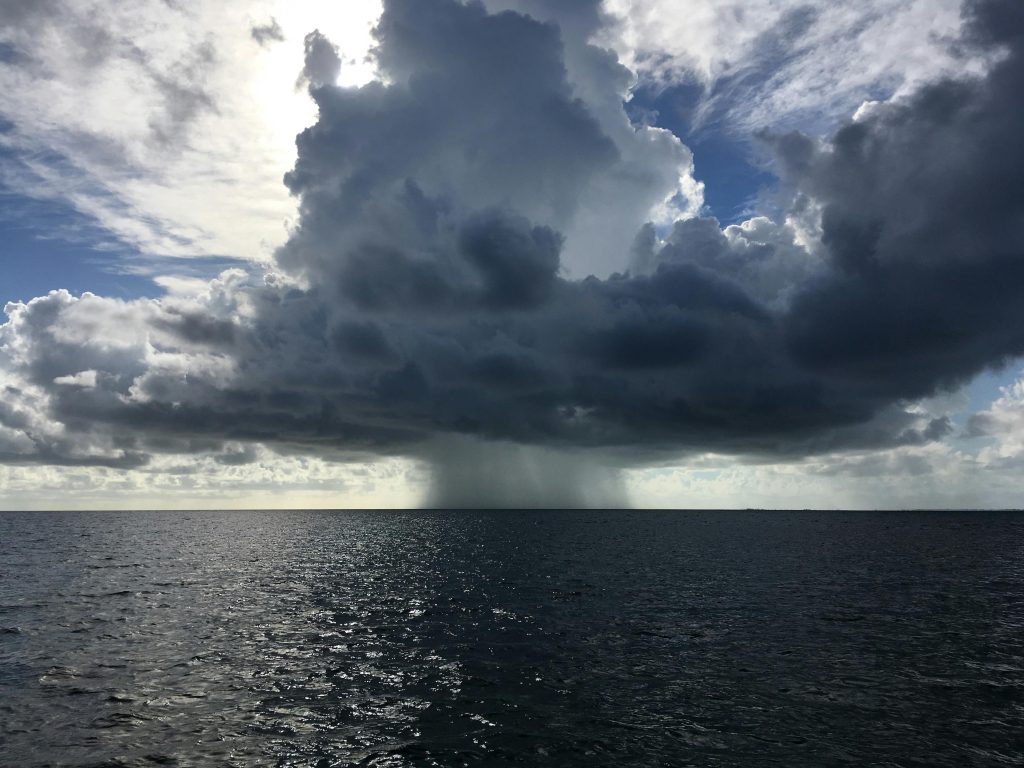 A rain cloud gathers over the ocean. (Photo courtesy: Brian Cook via Unsplash)