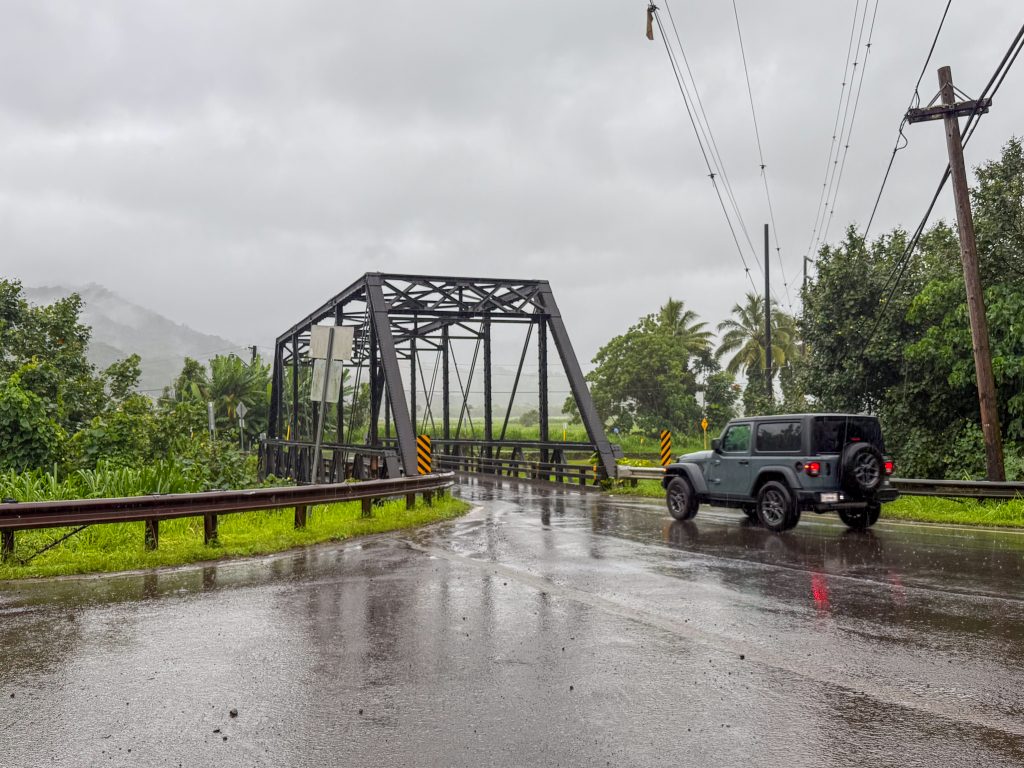 Few cars were on the road as this Jeep crosses the Hanalei Bridge as Tropical Storm Lala moved closer to Kauaʻi on the morning of Aug. 16, 2026. (Xiomara Yamileth/Kauaiʻi Now)