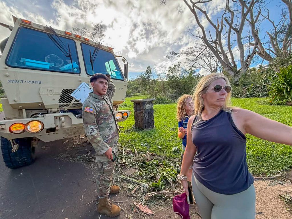 A Hawaiʻi National Guardsman who flew in from Honolulu was in disbelief as a resident points to the Hurricane Lowell damage on Kalihiwai Road in Princeville on Sept. 8, 2026. (Xiomara Yamileth/Kauaʻi Now)